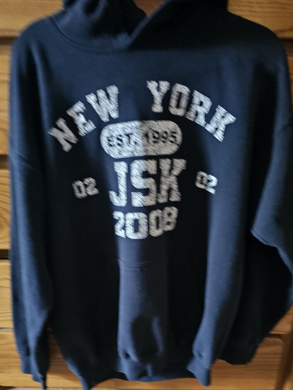 Black hooded sweatshirt featuring a distressed vintage varsity graphic NY Sz LG